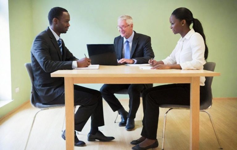 Trois professionnels en réunion autour d'une table, discutant de la mise en place de la formation renouvellement CSE